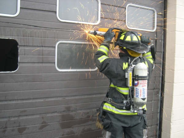 Firefighter Cutting the Garage Door at the Yorktown Autobody Fire